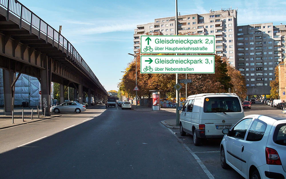 Fotomontage: Skalitzer Straße am Wassertorplatz mit vorgeschlagener Fahrradwegweisung am Lichtmast.