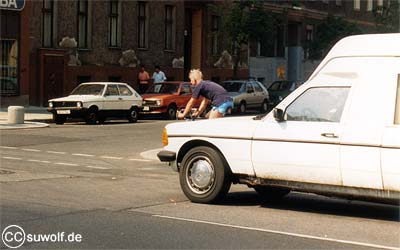 Foto: Radfahrer fährt auf Radweg hinter parkenden Autos und ist kaum zu sehen. 