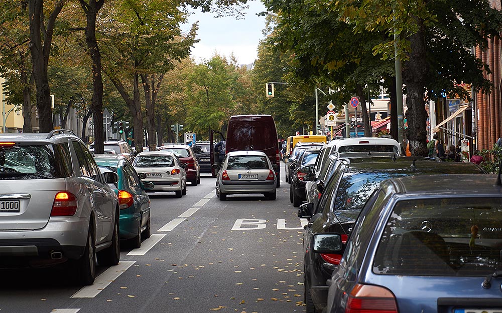 Foto: Frisch markierte Busspur mit parkenden Fahrzeugen und Ladetätigkeit in zweiter Reihe.